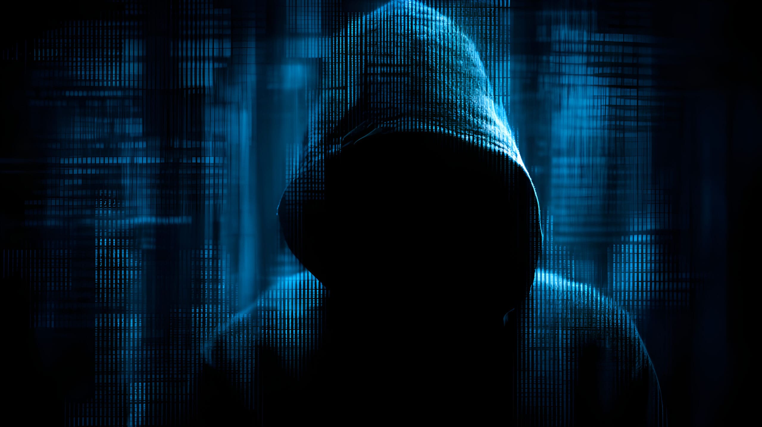 Hooded hacker launching cyberattack, breaking through digital security systems Anonymous hacker in a hooded sweatshirt representing dark web cyber security threats and data breaches.