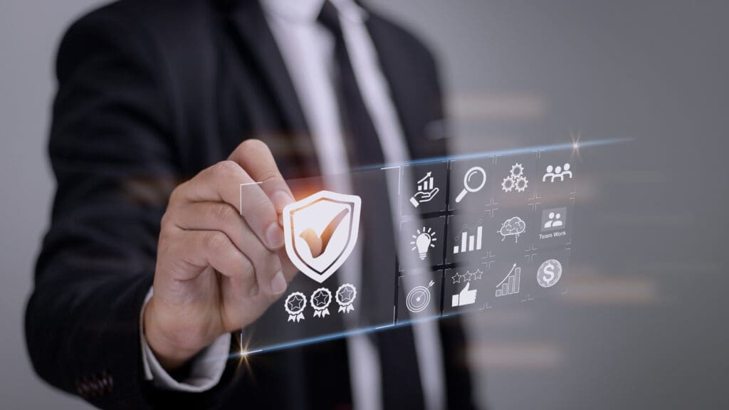 Business professional selecting a digital shield with a checkmark, symbolising cyber security compliance and certification.