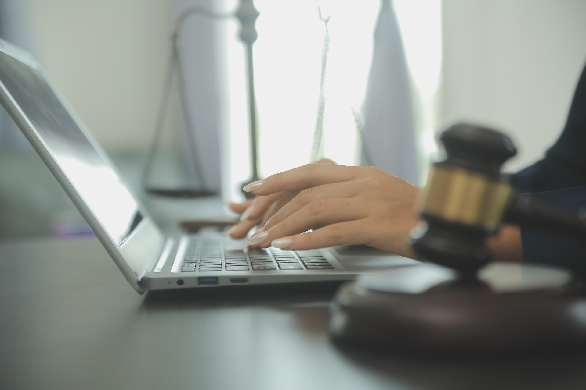 Essential Eight for Law Firms Australia Lawyer at a desk with a judge's gavel and scales of justice, representing Essential Eight compliance for Australian law firms